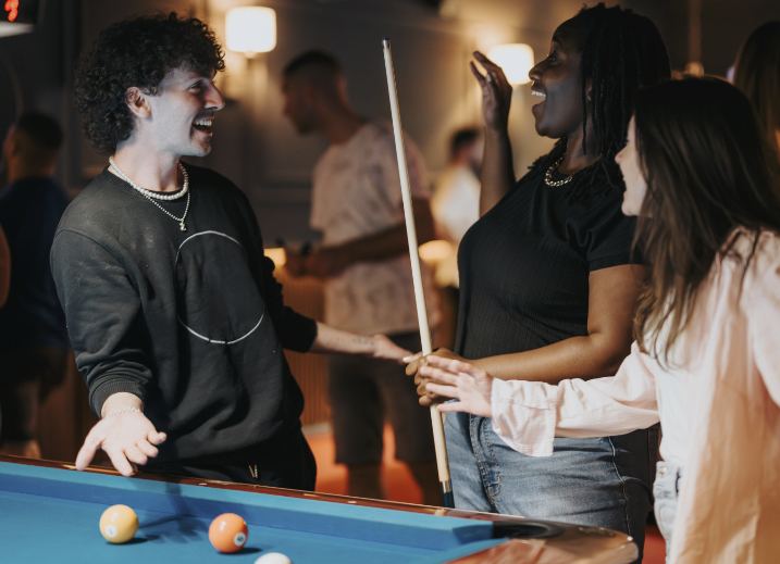 Competitive Socialising friends playing pool at a retail destination